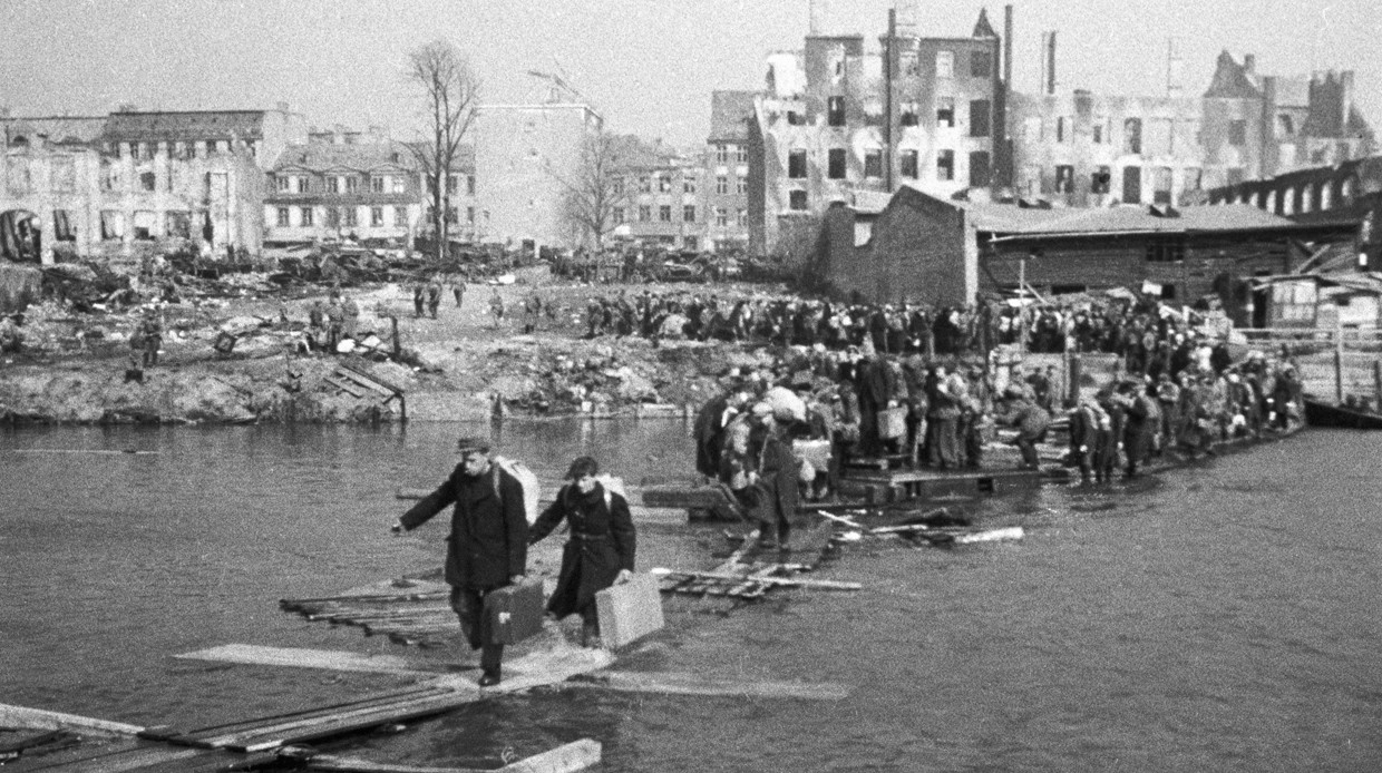 Жители Кенигсберга по временным мосткам переправляются через реку, возвращаясь домой