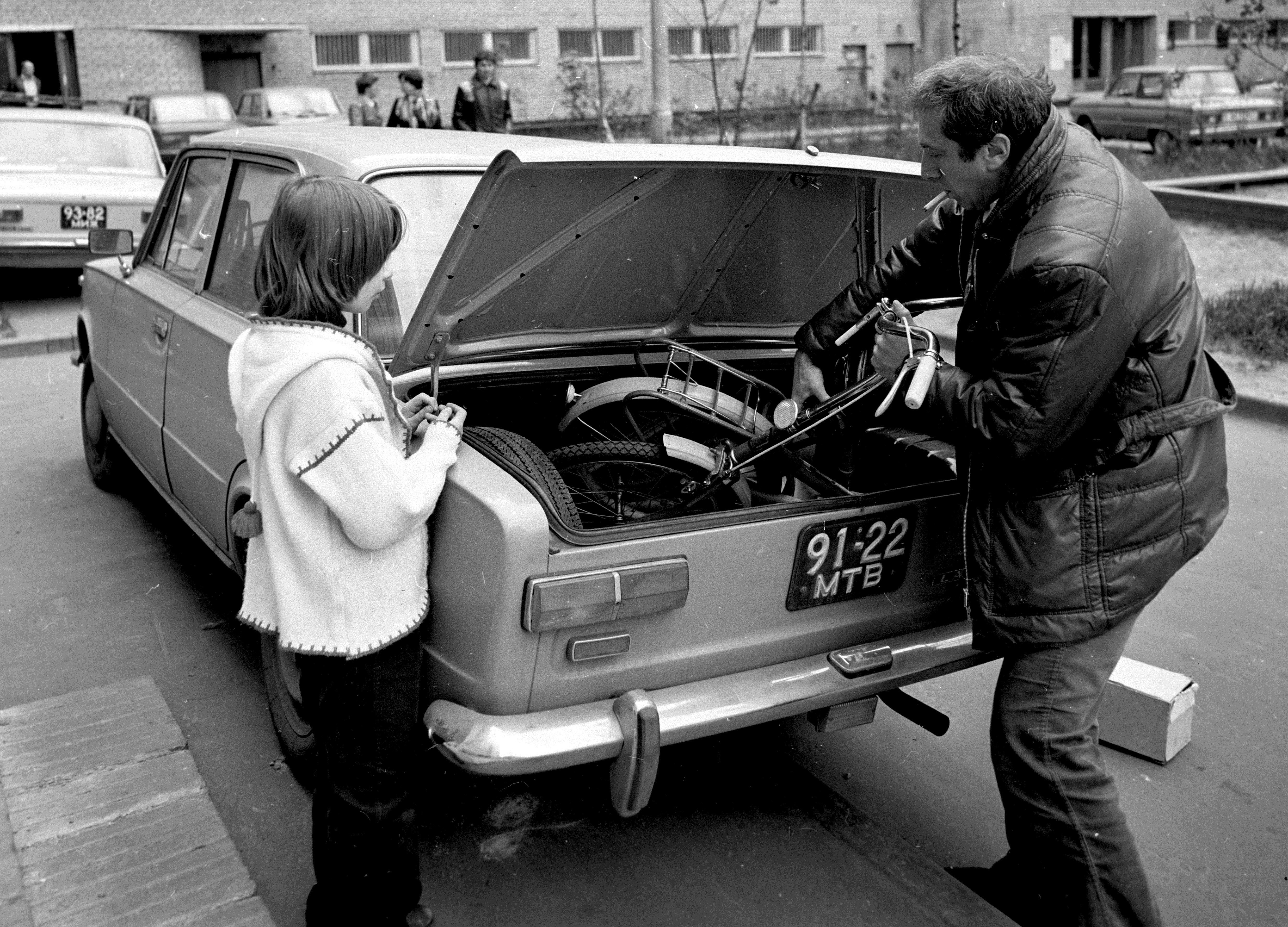 Актер Сергей Юрский и его дочь Дарья складывают велосипед в багажник своего автомобиля. 