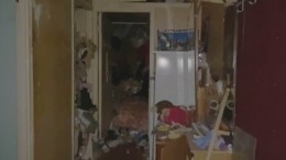 Видео: найденное в петербургской квартире-свалке тело женщины выносят из дома
