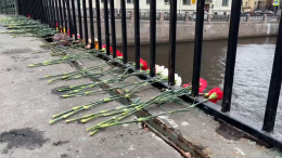 Жители Петербурга продолжают нести цветы к месту падения автобуса в реку